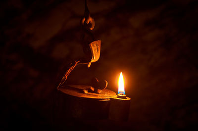 Close-up of lit candle in darkroom