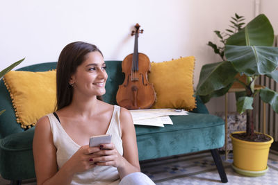 Young woman using mobile phone at home