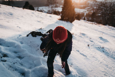 Rear view of woman walking on snowy field