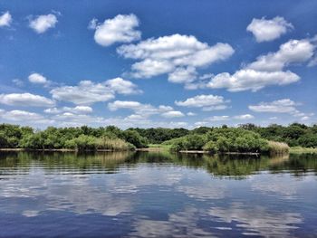 Scenic view of lake against cloudy sky