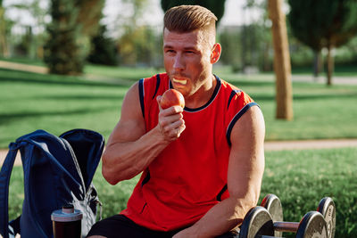 Side view of young man holding car