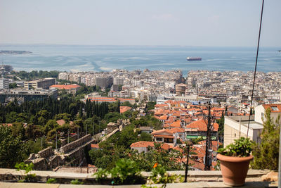 High angle view of cityscape by sea against sky