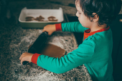 The kitchen becomes a hub of holiday excitement as a boy and his mom prepare christmas gingerbread