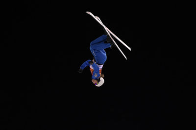 Woman jumping against black background