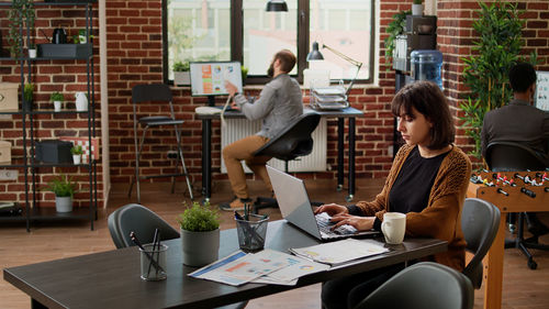 Side view of woman using digital tablet in creative office