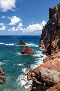 Scenic view of rocks in sea against sky