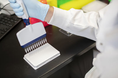 Overhead close up view of scientist using multi channel pipette