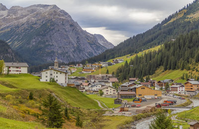 Houses by buildings against sky