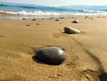 Close-up of pebbles on beach against sky