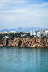 Buildings by sea against sky