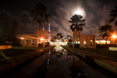 Illuminated city against sky at night