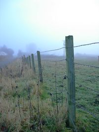 Fence on field against sky