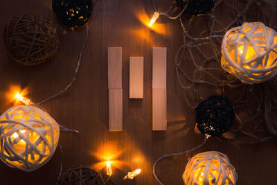 Directly above shot of letter m blocks and illuminated lights on wooden table