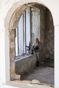 Rear view of woman sitting in front of historic building