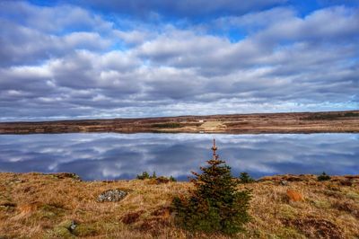 Scenic view of lake against cloudy sky