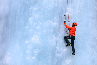 Side view of woman ice climbing