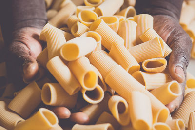 Close-up of hands holding fresh pasta in factory
