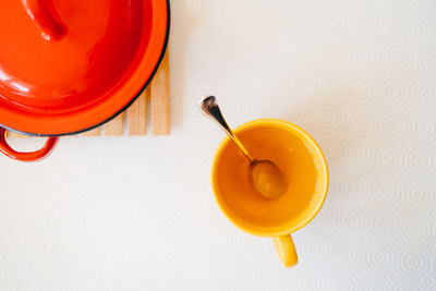 High angle view of yellow mug with a drink on table
