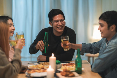 Young man drinking glass on table