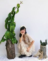 Portrait of young woman standing against plants