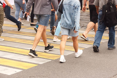 Low section of people walking on road