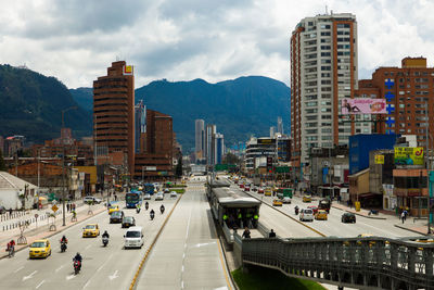 Traffic on road by buildings against sky