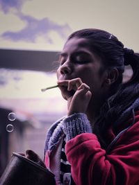 Close-up of young woman blowing bubbles