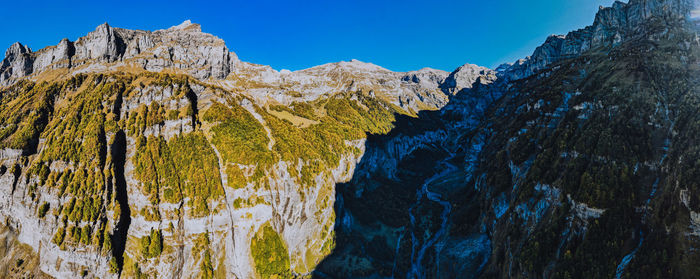 Scenic view of mountains against clear blue sky