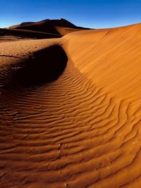 Sand dunes in desert against sky