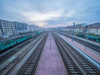 Railroad tracks in city against sky