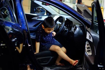 Rear view of boy sitting in car