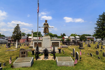 Statue on cemetery against sky