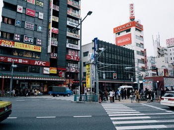 People on city street against buildings 