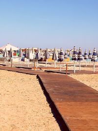 People on beach against clear sky