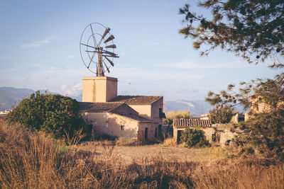 American-style windmill by houses against sky