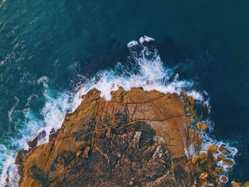 High angle view of waves breaking on rocks