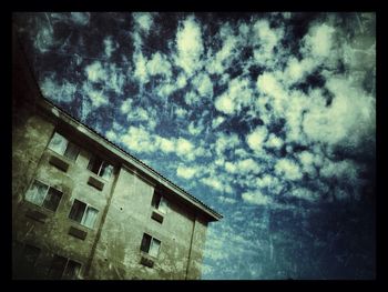 Low angle view of building against cloudy sky