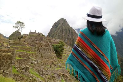Female traveler looking at machu picchu, unesco world heritage site in cusco region of peru