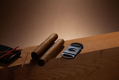 Siesta. two cigars and matches on the wooden beam.brown background.