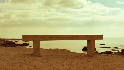 Lifeguard hut on beach against sky