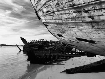 Abandoned boat in sea against sky