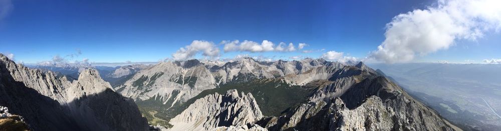 Panoramic view of snowcapped mountains against blue sky