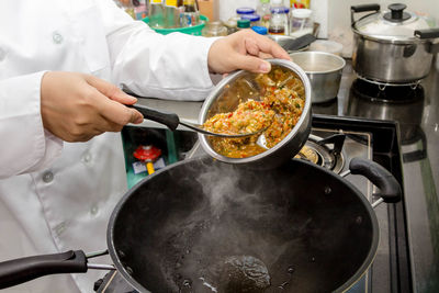 Midsection of man preparing food in kitchen