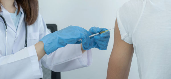 Midsection of woman holding white umbrella