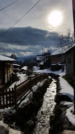 Houses in town against sky during winter