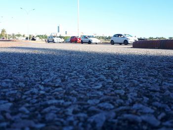 Surface level of vehicles on road against clear sky