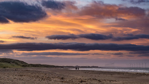 Scenic view of beach against sky during sunset