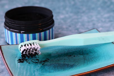 Close-up of toothbrush in tray by bottle on table