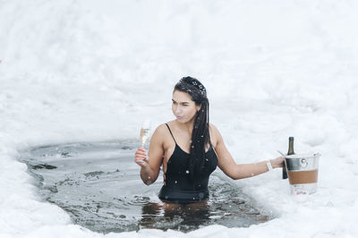 Portrait of young woman standing on snow