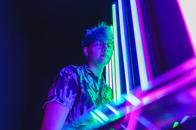 Portrait of young man looking at illuminated stage